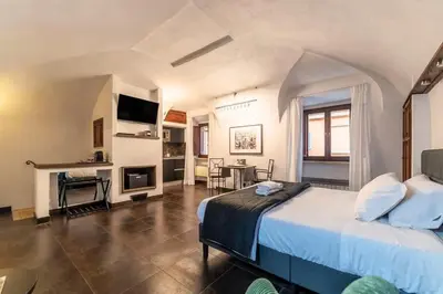 a bedroom with a large bed and a living room at Loft a due passi dal Pantheon in Rome