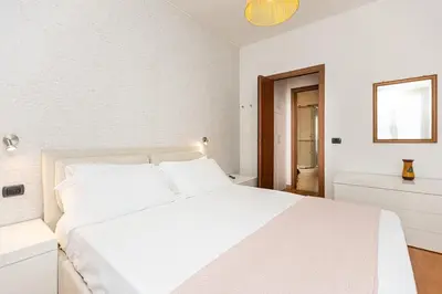 a white bedroom with a white bed and a window at Quieto alloggio vicino stazione e metropolitana in Rome