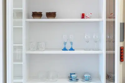 a white shelf with wine glasses on it at Quieto alloggio vicino stazione e metropolitana in Rome