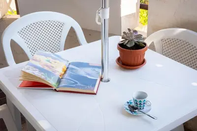 a white table with a book and a plant on it at Quieto alloggio vicino stazione e metropolitana in Rome