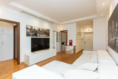 a living room with a white couch and a tv at Quieto alloggio vicino stazione e metropolitana in Rome