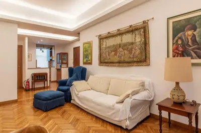 a living room with a white couch and blue chairs at Appartamento ben collegato con aeroporto e centro in Rome