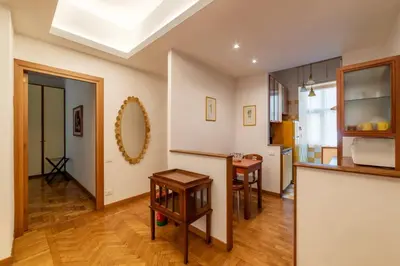 a living room with a kitchen and a table at Appartamento ben collegato con aeroporto e centro in Rome