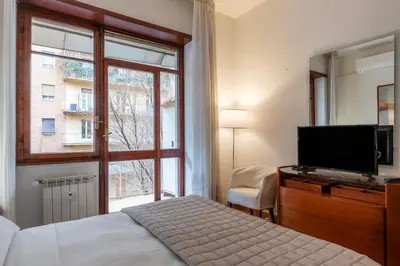 a bedroom with a bed and a television and a window at Appartamento ben collegato con aeroporto e centro in Rome