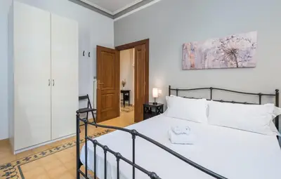 a bedroom with a bed in a white room at 4 comodi posti letto con giardino al Colosseo in Rome