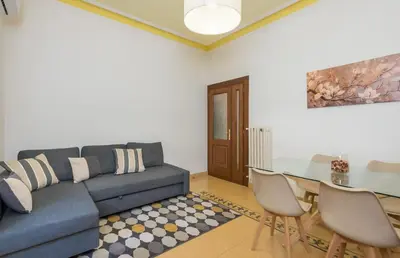 a living room with a blue couch and a glass table at 4 comodi posti letto con giardino al Colosseo in Rome