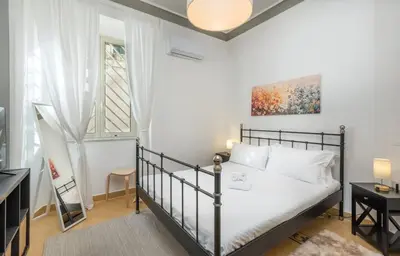 a bedroom with a bed and a large window at 4 comodi posti letto con giardino al Colosseo in Rome