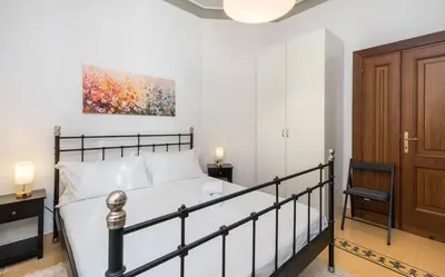 a bedroom with a bed and a painting on the wall at 4 comodi posti letto con giardino al Colosseo in Rome