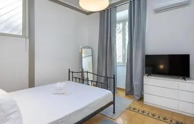 a bedroom with a bed and a flat screen tv at 4 comodi posti letto con giardino al Colosseo in Rome