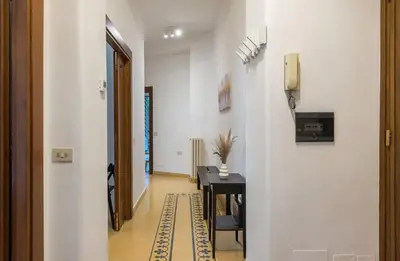a hallway with a table and a phone on a wall at 4 comodi posti letto con giardino al Colosseo in Rome