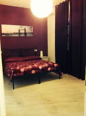 a bedroom with a bed with a red wall at Appartamenti Romatour in Rome