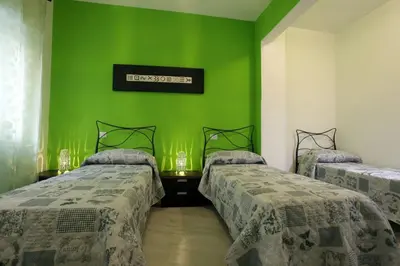 two beds in a room with green walls at Appartamenti Romatour in Rome
