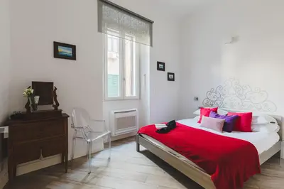 a bedroom with a bed with a red blanket and a window at Domus Degli Angeli in Rome