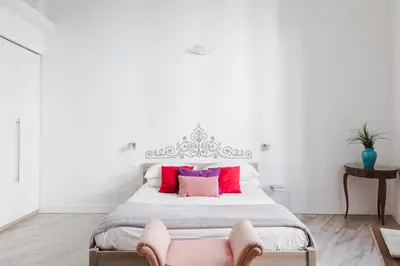 a bedroom with a large bed with pink pillows at Domus Degli Angeli in Rome
