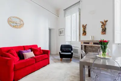 a living room with a red couch and a chair at Domus Degli Angeli in Rome