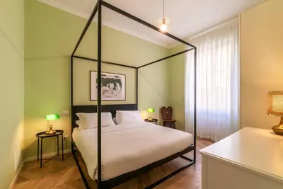 a bedroom with a four poster bed with white sheets at Elegante appartamento vicino il Vaticano in Rome