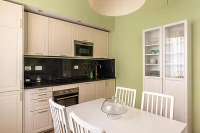 a kitchen with a white table and white cabinets at Elegante appartamento vicino il Vaticano in Rome