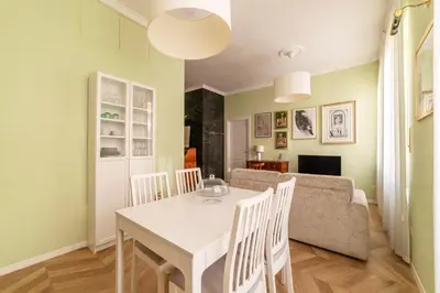 a dining room and living room with a white table and chairs at Elegante appartamento vicino il Vaticano in Rome