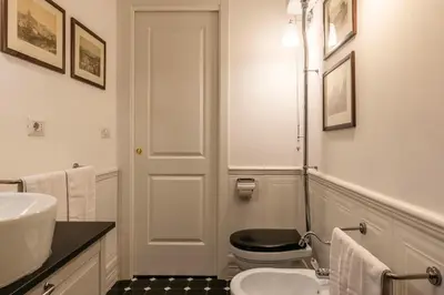 a white bathroom with a toilet and a sink at Elegante appartamento vicino il Vaticano in Rome