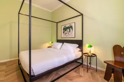 a bedroom with a canopy bed with white sheets at Elegante appartamento vicino il Vaticano in Rome