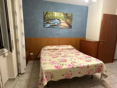 a small bedroom with a bed with a floral bedspread at Sofia Holiday Home in Rome