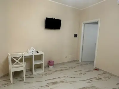 a room with a table and a television on a wall at Sofia Holiday Home in Rome
