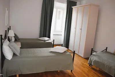 a bedroom with two beds and a large window at Apartment Termini in Rome