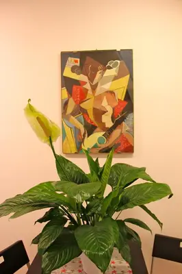 a plant sitting on a table in front of a painting at Lo Studio Guest House in Rome