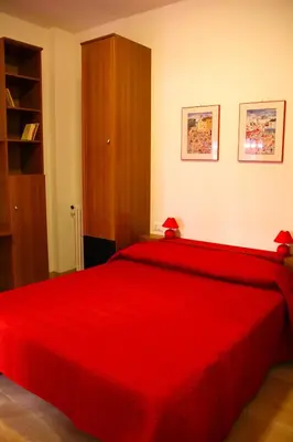 a bedroom with a red bed with red sheets at Lo Studio Guest House in Rome