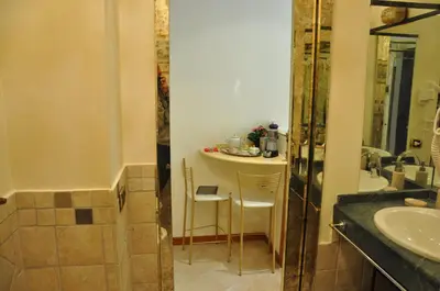 a bathroom with a shower and a table and a sink at Rome Imperial Crown in Rome