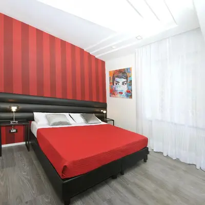 a red bedroom with a bed with a red headboard at Il Cavaliere in Rome