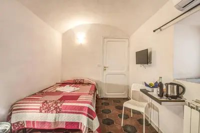a small room with a bed and a table and a sink at Relais La Torretta in Rome