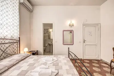 a white room with a bed and a bathroom at Relais La Torretta in Rome