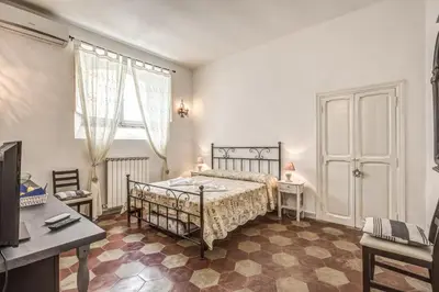 a bedroom with a bed and a desk and a window at Relais La Torretta in Rome