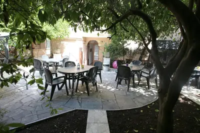 a patio with tables and chairs under a tree at NEW GENERATION HOSTEL Rome center in Rome