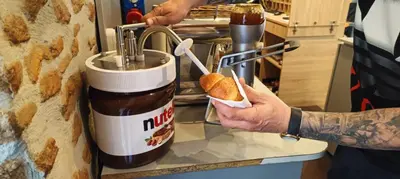 a man is putting a peanut butter sandwich into a mixer at NEW GENERATION HOSTEL Rome center in Rome