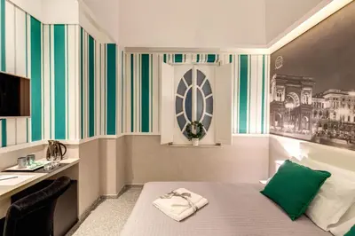 a bedroom with a bed with green and white stripes at Grand Tour Rome Suites - Liberty Collection in Rome