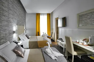 a hotel room with two beds and a desk at Domus Castroni Pompeo Magno in Rome