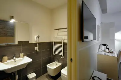a bathroom with a sink and a toilet and a mirror at Domus Castroni Pompeo Magno in Rome
