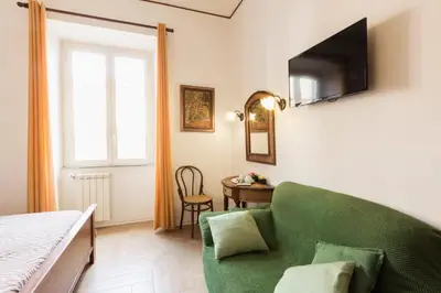 a bedroom with a green couch and a table at TrastEver Holiday in Rome