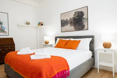 a bedroom with a large bed with an orange blanket at Dimora Aniene in Rome