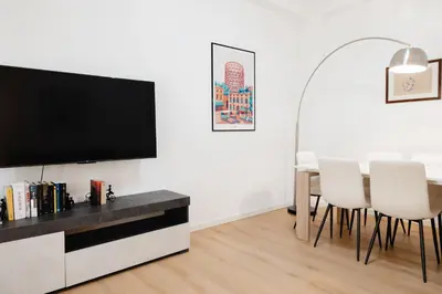 a living room with a tv and a table with chairs at Dimora Aniene in Rome
