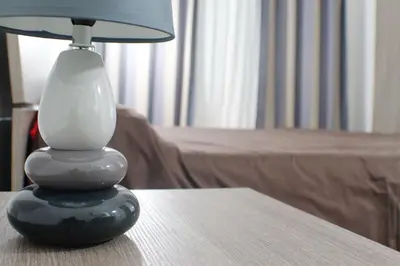 a lamp sitting on a table next to a bed at Vatican In The Moonlight Apartment in Rome