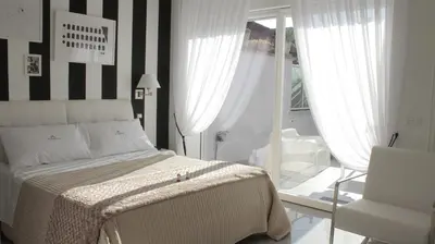 a bedroom with a bed and a chair and a window at Glamroom Luxury Terrace in Rome