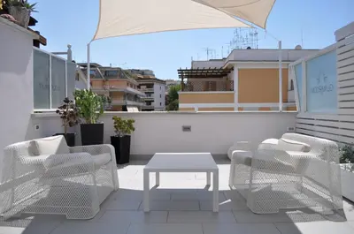 a patio with chairs and a table on a balcony at Glamroom Luxury Terrace in Rome