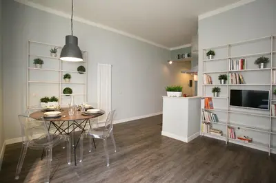 a dining room with a table and chairs and bookshelves at Cola Di Rienzo A E B in Rome