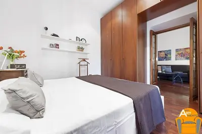 a bedroom with a white bed and a desk at 4BNB - Vatican Doors Flat in Rome