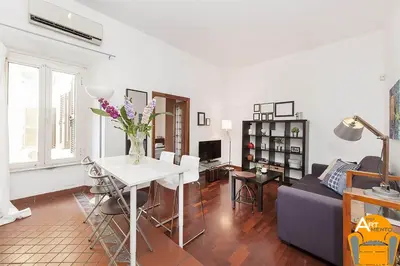 a living room with a couch and a table with flowers at 4BNB - Vatican Doors Flat in Rome