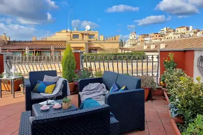 a patio with two chairs and a table on a balcony at Spagna Penthouse in Rome