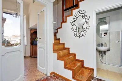 a staircase in a bathroom with a sink and a mirror at Spagna Penthouse in Rome